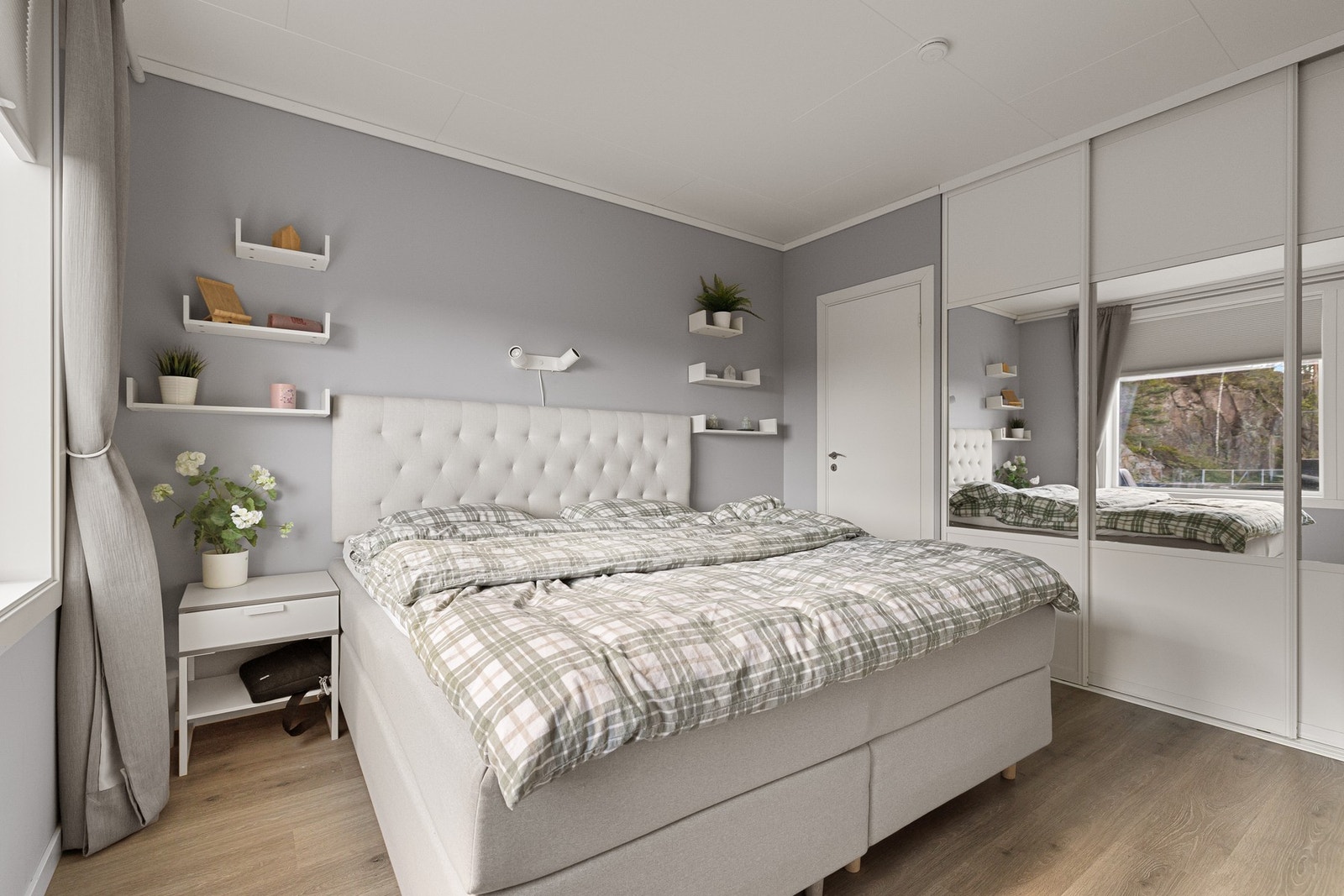 Bildet viser det flotte hovedsoverommet, som har sjenerøs størrelse og en praktisk skyvedørsgarderobe med speilglass. Døren er til en innvendig bod/garderobe. Galleribilde