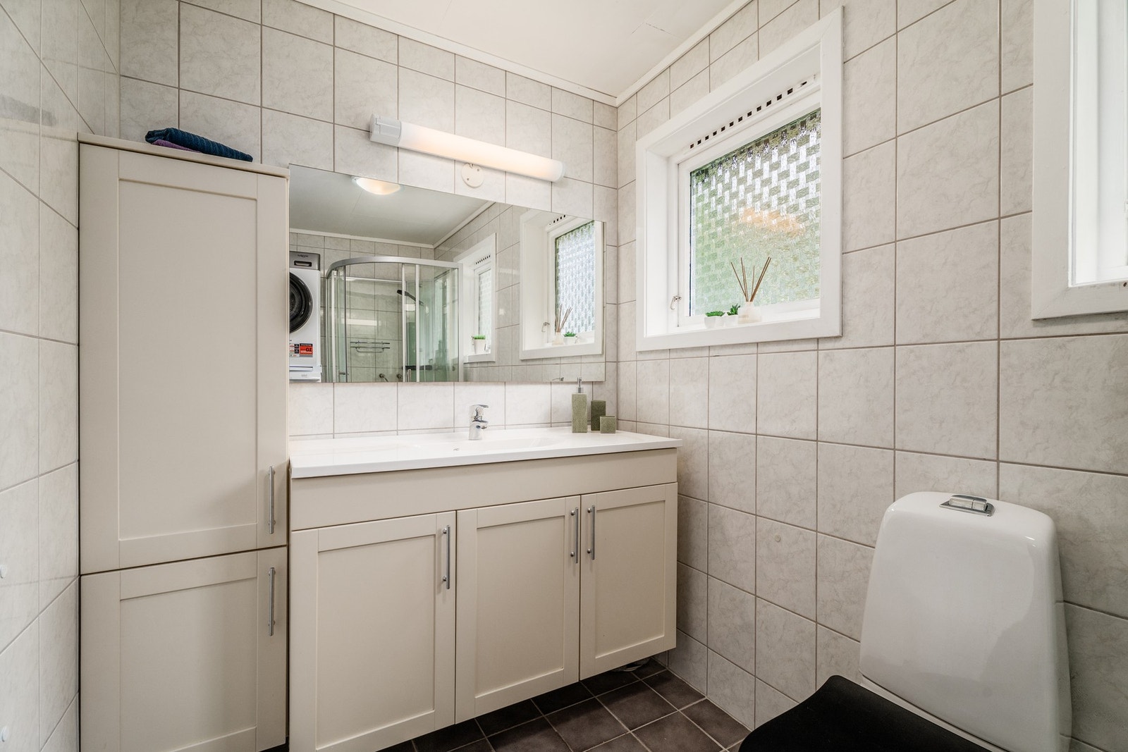 Badet har en romslig innredning med god skapplass og en stor servant. Galleribilde