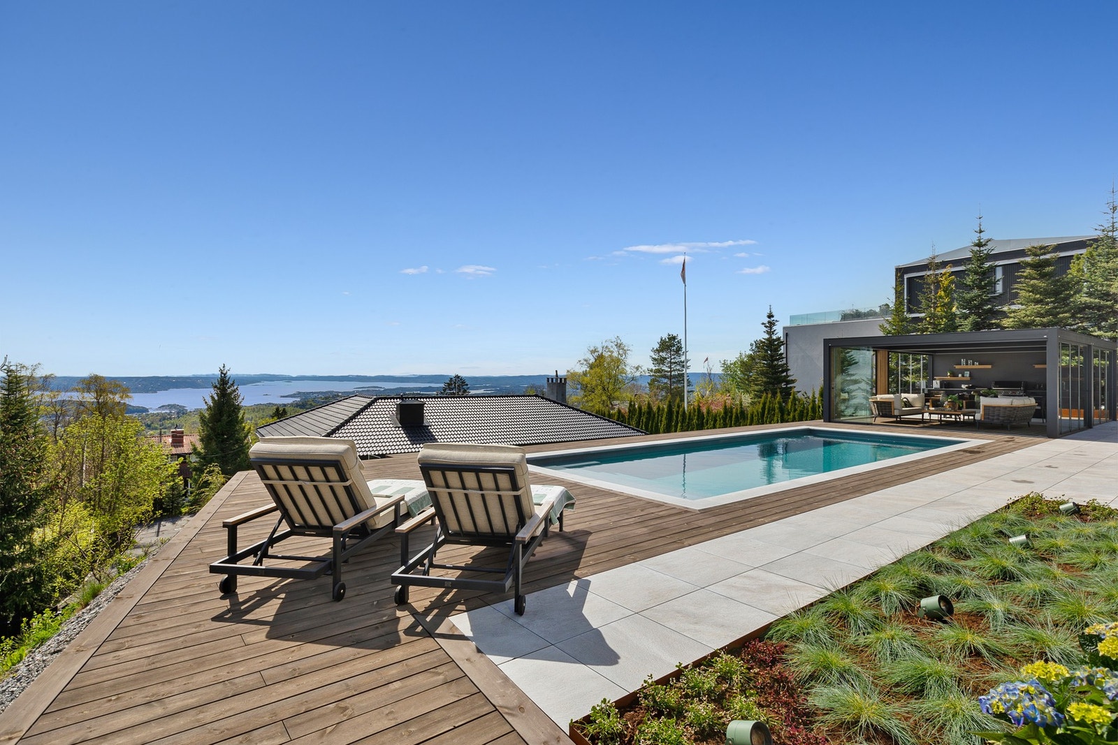 Nyt sommerdagene ved svømmebassenget, komplett med praktisk utedusj, ny pergola og solrike uteplasser som innbyr til både avslapning og sosiale stunder. Galleribilde