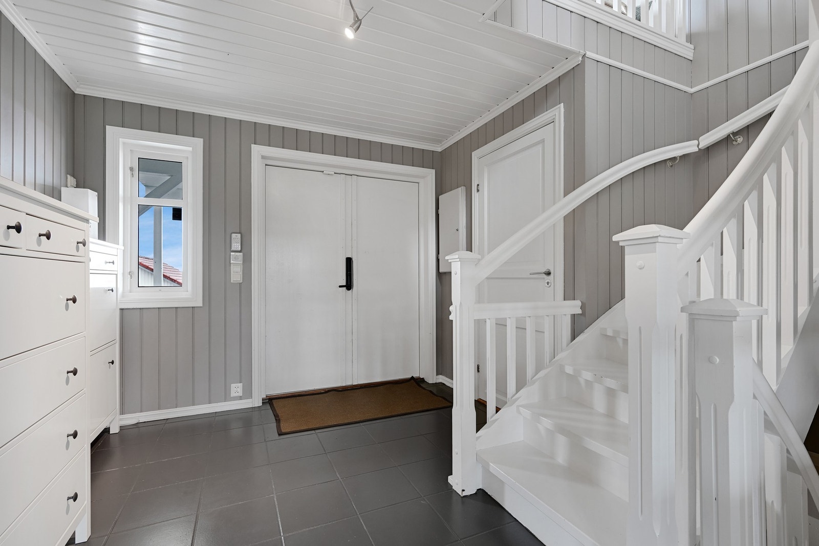 Romslig og flislagt hall med god plass for garderobe og skoskap Galleribilde