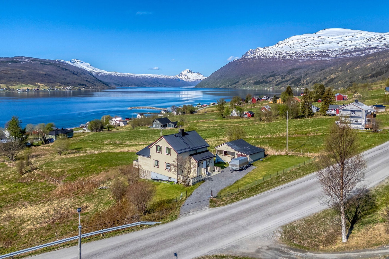 Oversiktsbilde som viser eiendommen og dens nærhet til fjorden. Galleribilde