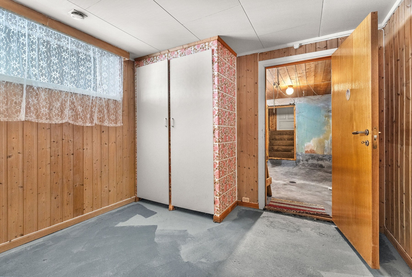 Innredet rom i kjeller med panelvegger og støpt gulv. Galleribilde