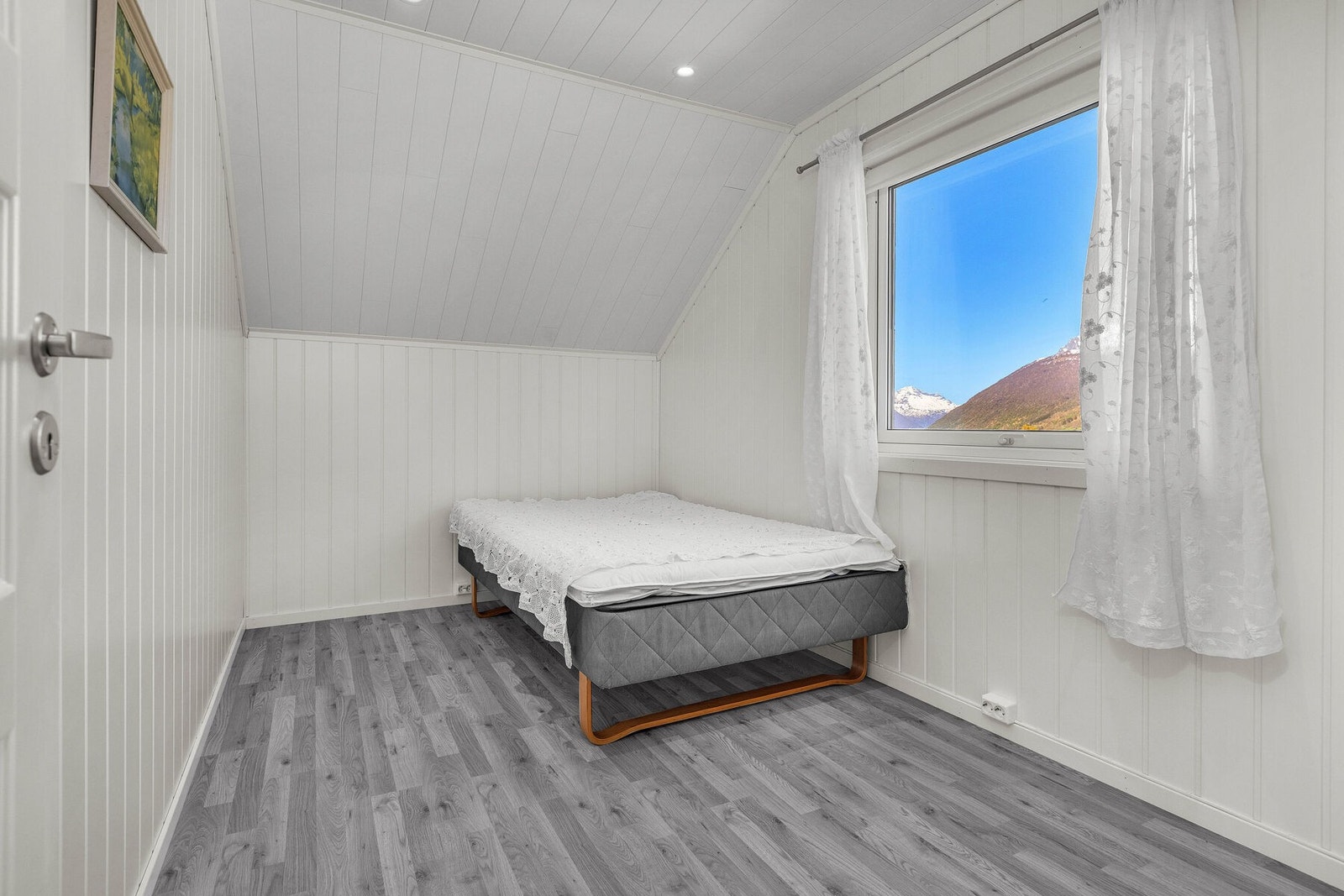 Innredet rom på loftet med laminatgulv og panel på vegger og i tak. Galleribilde