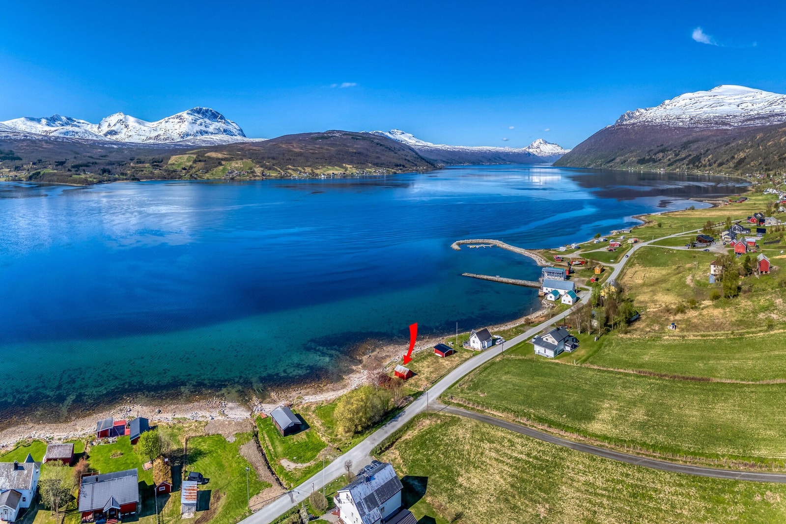 Naustet er markert med pil, og har en idyllisk plassering i strandkanten. Galleribilde