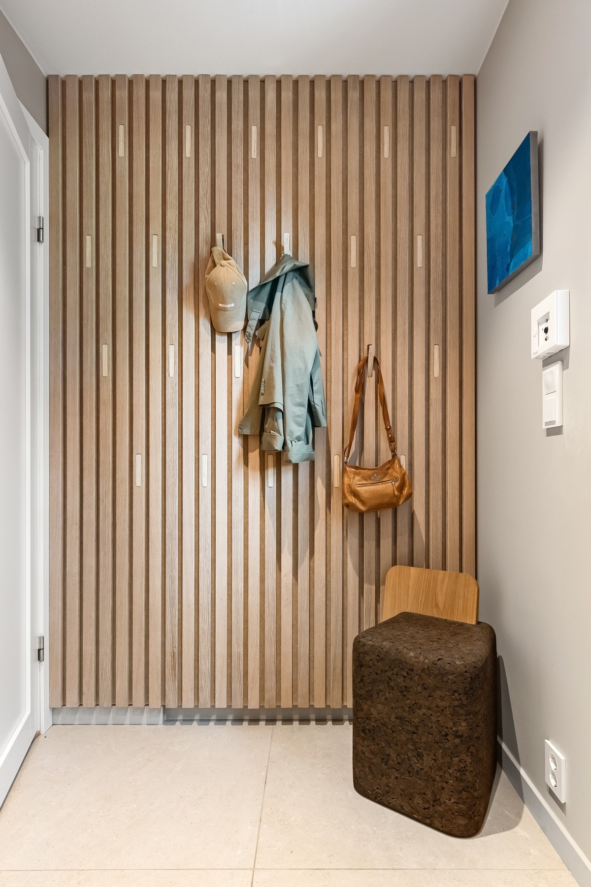 Spesialdesignet spilevegg fra WALL-IT med integrerte utfellbare knagger for smart oppheng i gangen. Galleribilde