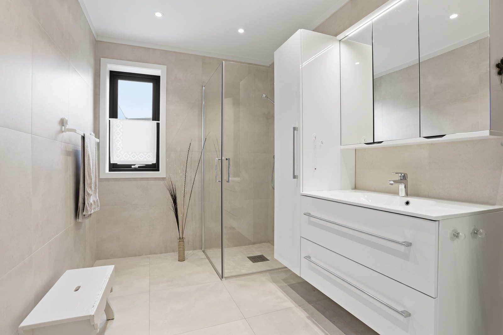 Badet i 1.etg. Gir et delikat inntrykk og inneholder veggmontert toalett, glassdører mot dusjnisje samt dusjgarnityr, innredning med skuffer og heldekkende servant samt vegghengt skap med speil. Galleribilde