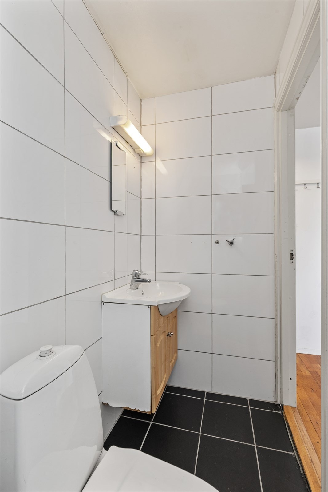 Badet er innredet med servant, speil og belysning, samt gulvmontert toalett. Galleribilde