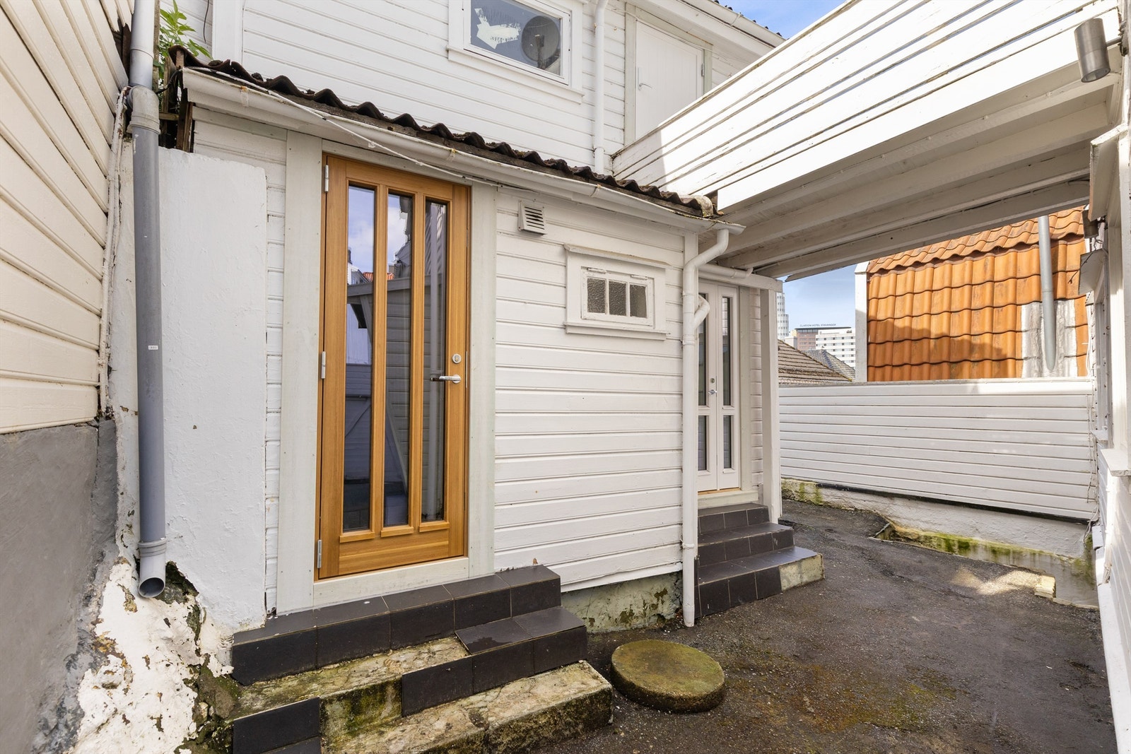 Uteområdet mellom hovedhuset og annekset, med adkomst til flere av enhetene. Galleribilde