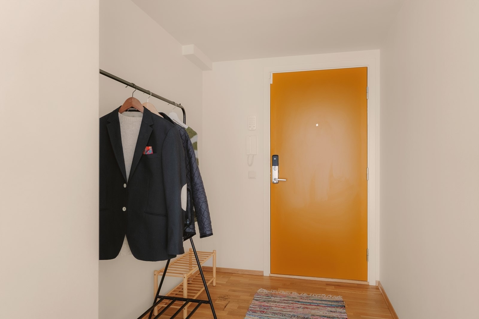Romslig og innbydende entré med god plass til oppbevaring. Porttelefon på vegg. Kodedør Galleribilde