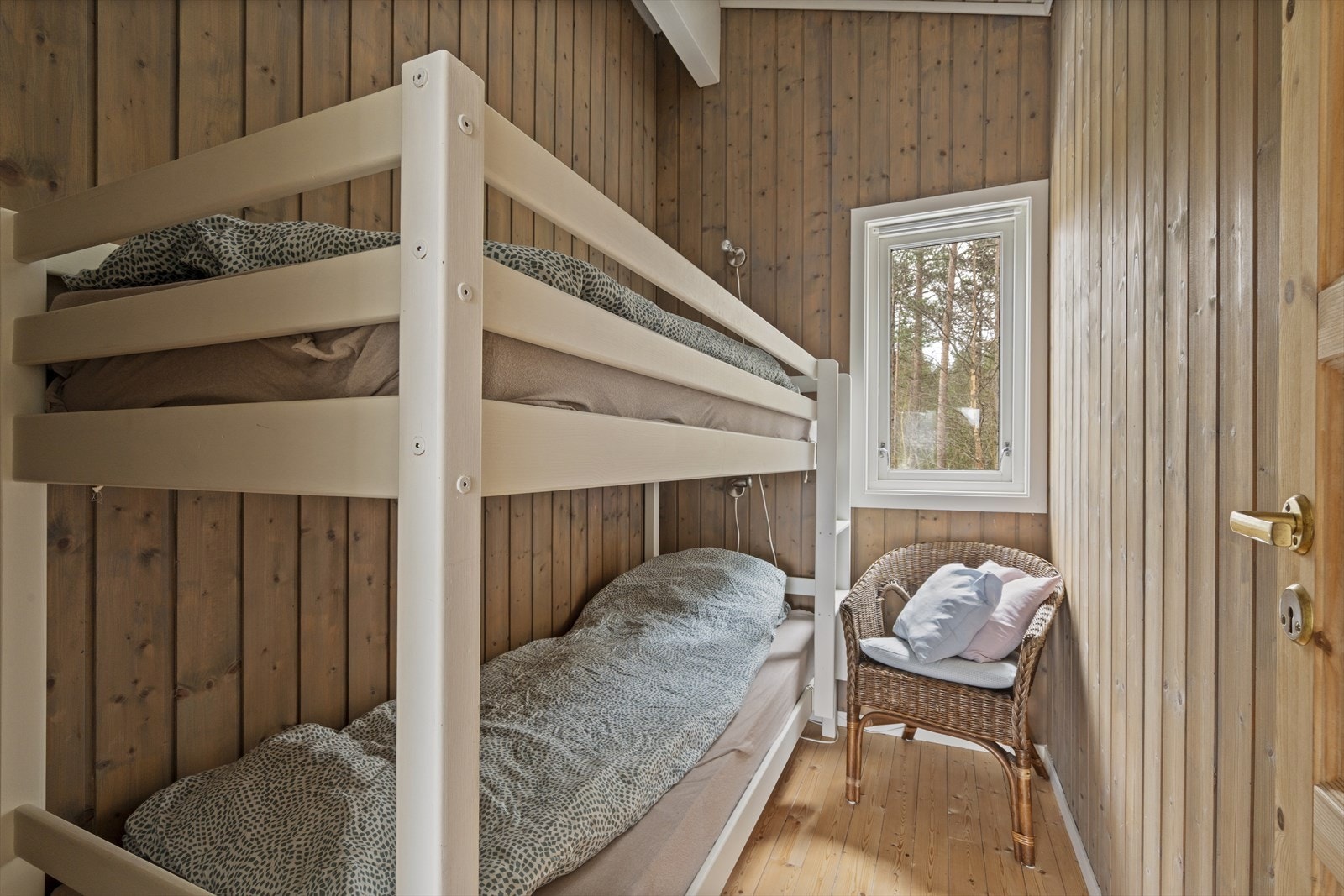 Soverom med plass til køyeseng, med vegger i trepanel og furugulv. Galleribilde