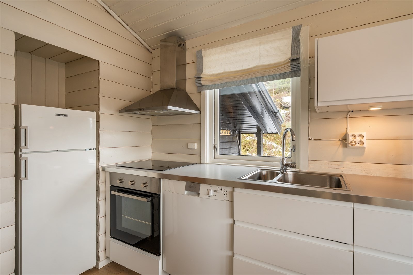 Kjøkkenet er utstyrt med platetopp, stekeovn, oppvaskmaskin og kjøl/fryseskap. Galleribilde
