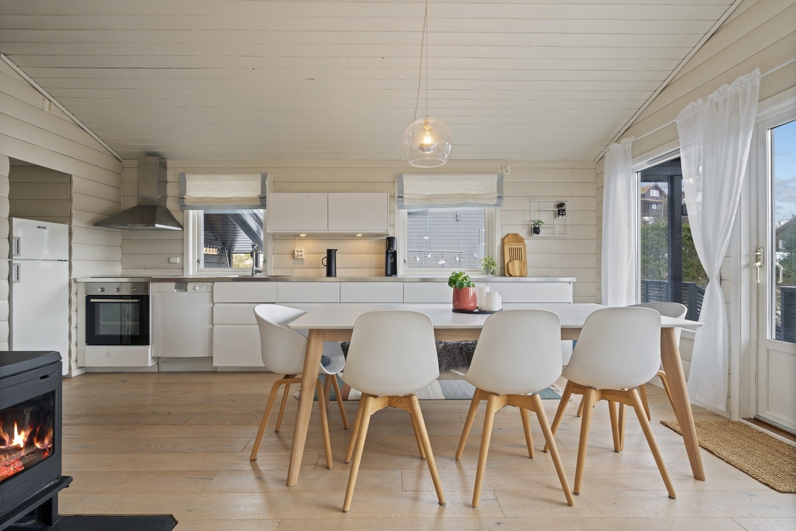 Åpen løsning mellom stue og kjøkken gir en sosial sone. Vedovnen sørger for ekstra varme og hygge. Galleribilde