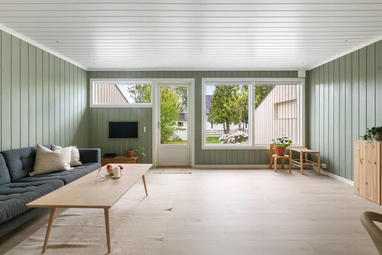 Store vindusflater og utgang til terrassen gir rikelig med dagslys i stuen. Galleribilde