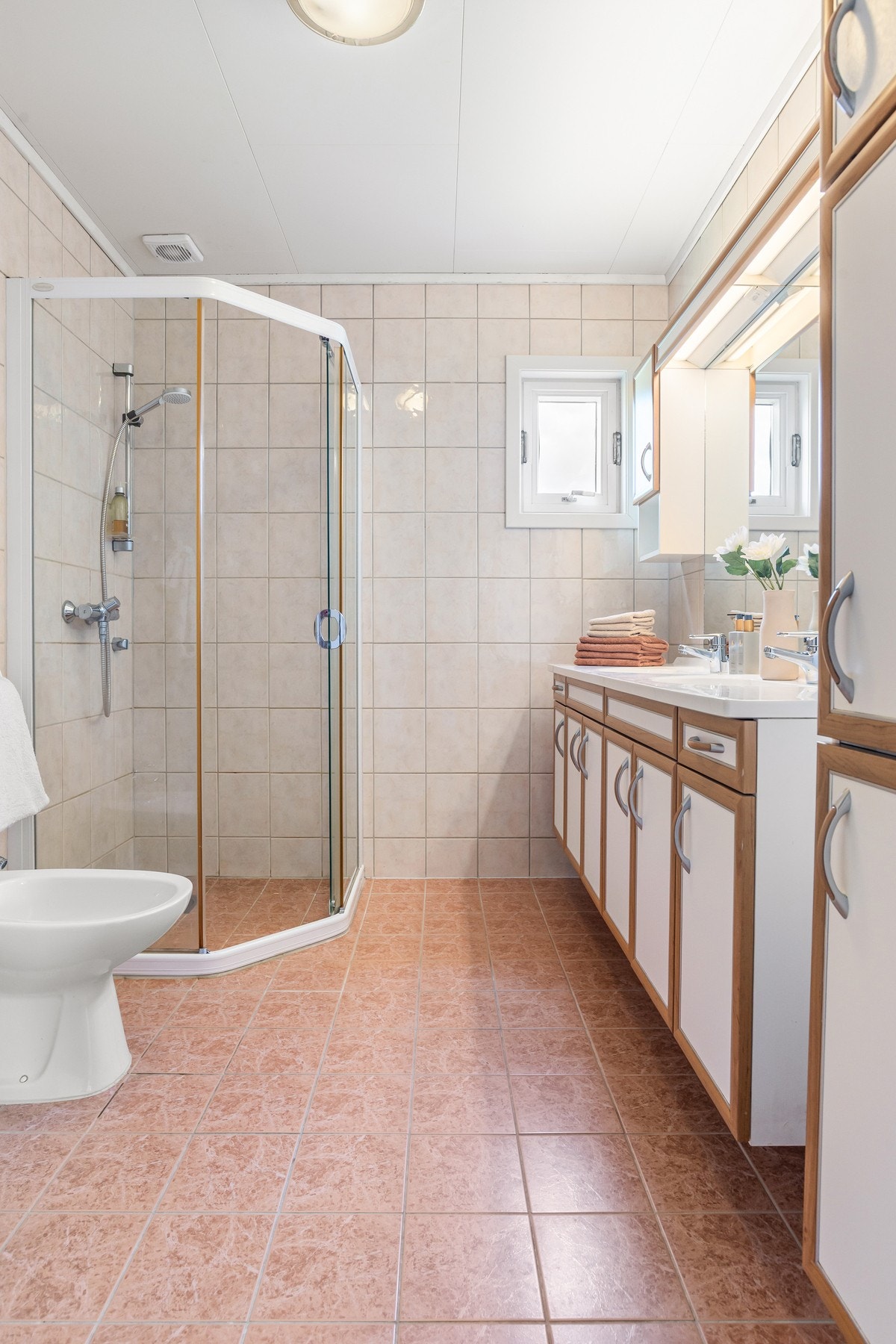 Badet i 2. etasje er romslig med fliser på gulv og vegger - Rommet er innredet med dusjnisje, servant og toalett Galleribilde