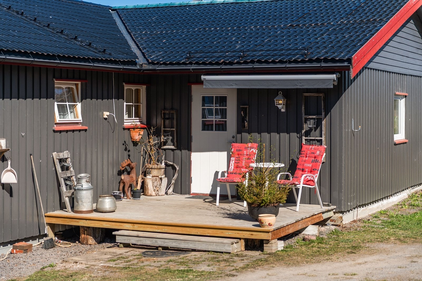 Inngangsparti med platting og terrassemarkise. Galleribilde