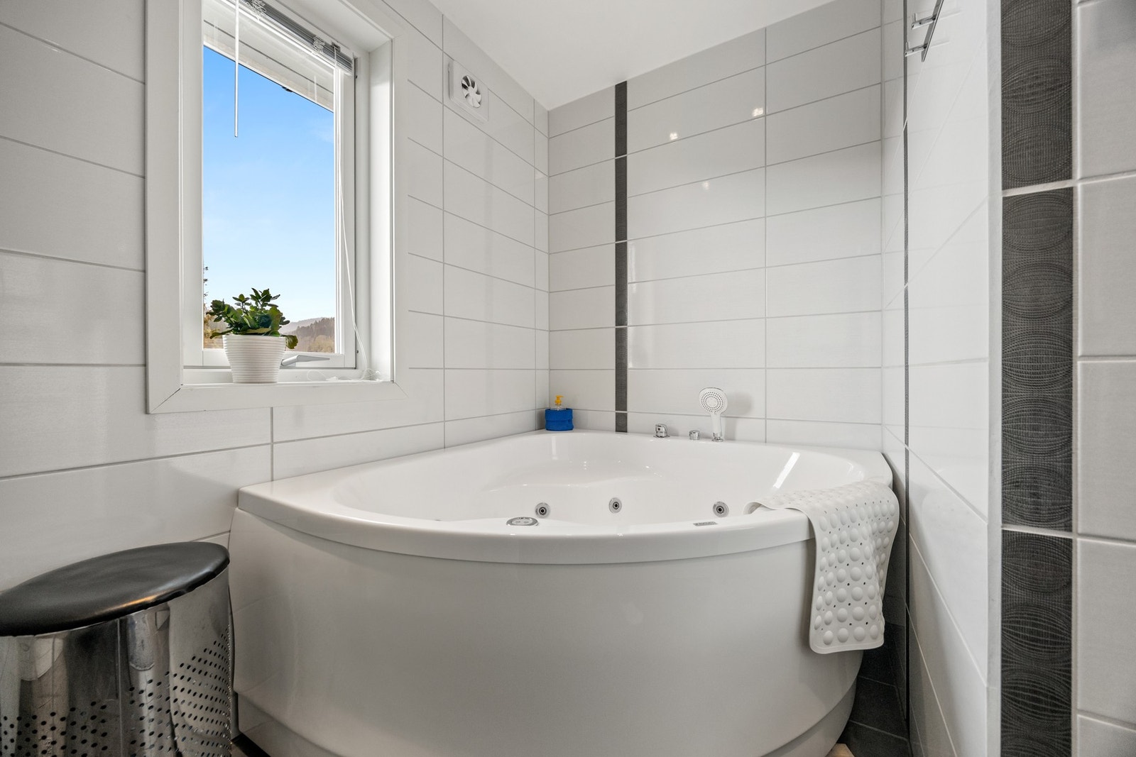 Badet er utstyrt med servantskap, innfellbare dusjdører og badekar. Galleribilde