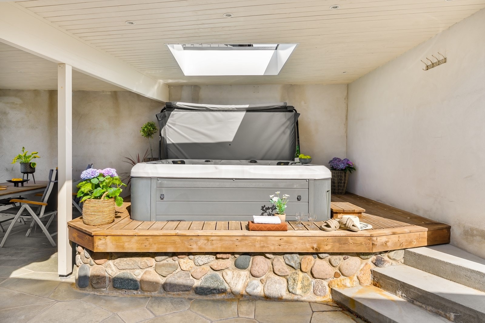 Jacuzzien er pent integrert i terrassegulvet med en ramme av tre og naturstein. Galleribilde