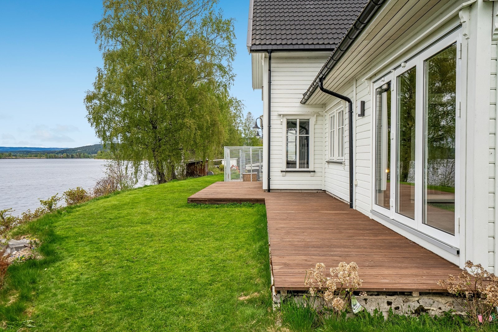 Utenfor stuen er en terrasse langs hele veggen mot nord. Terrassene har Møre Royal gulv fra 2021. Galleribilde