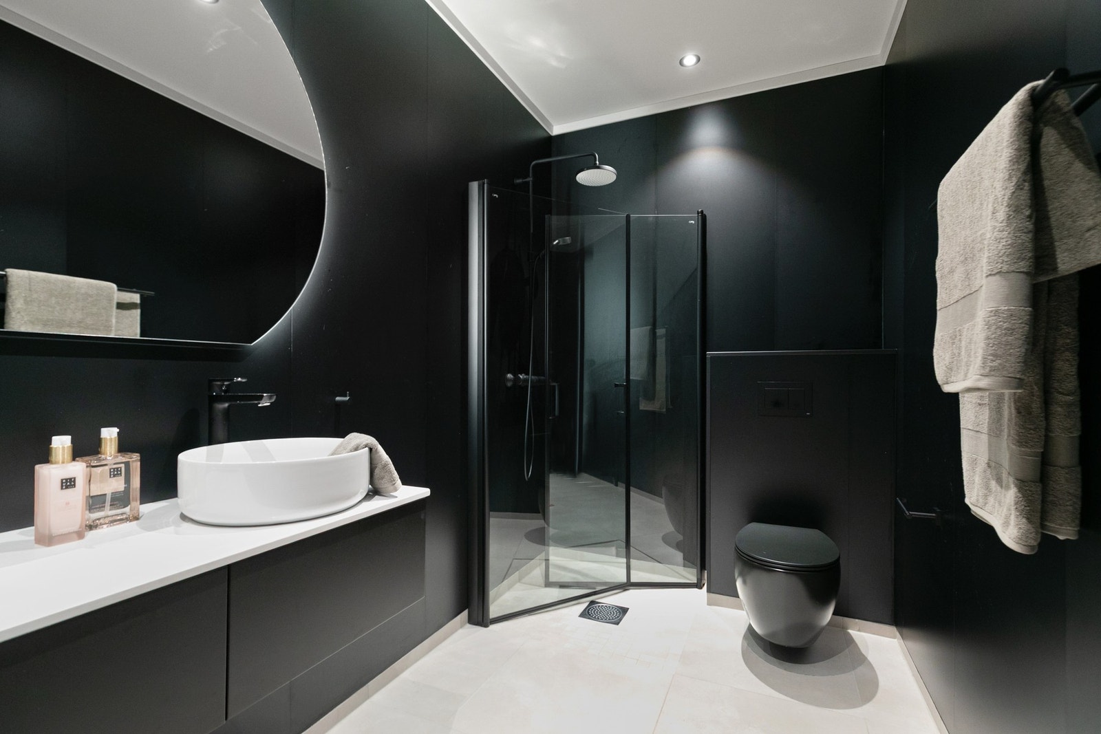 Badet i underetasjen har et moderne og stilrent uttrykk med mørke vegger som skaper en kontrast til de lyse gulvflisene. Galleribilde