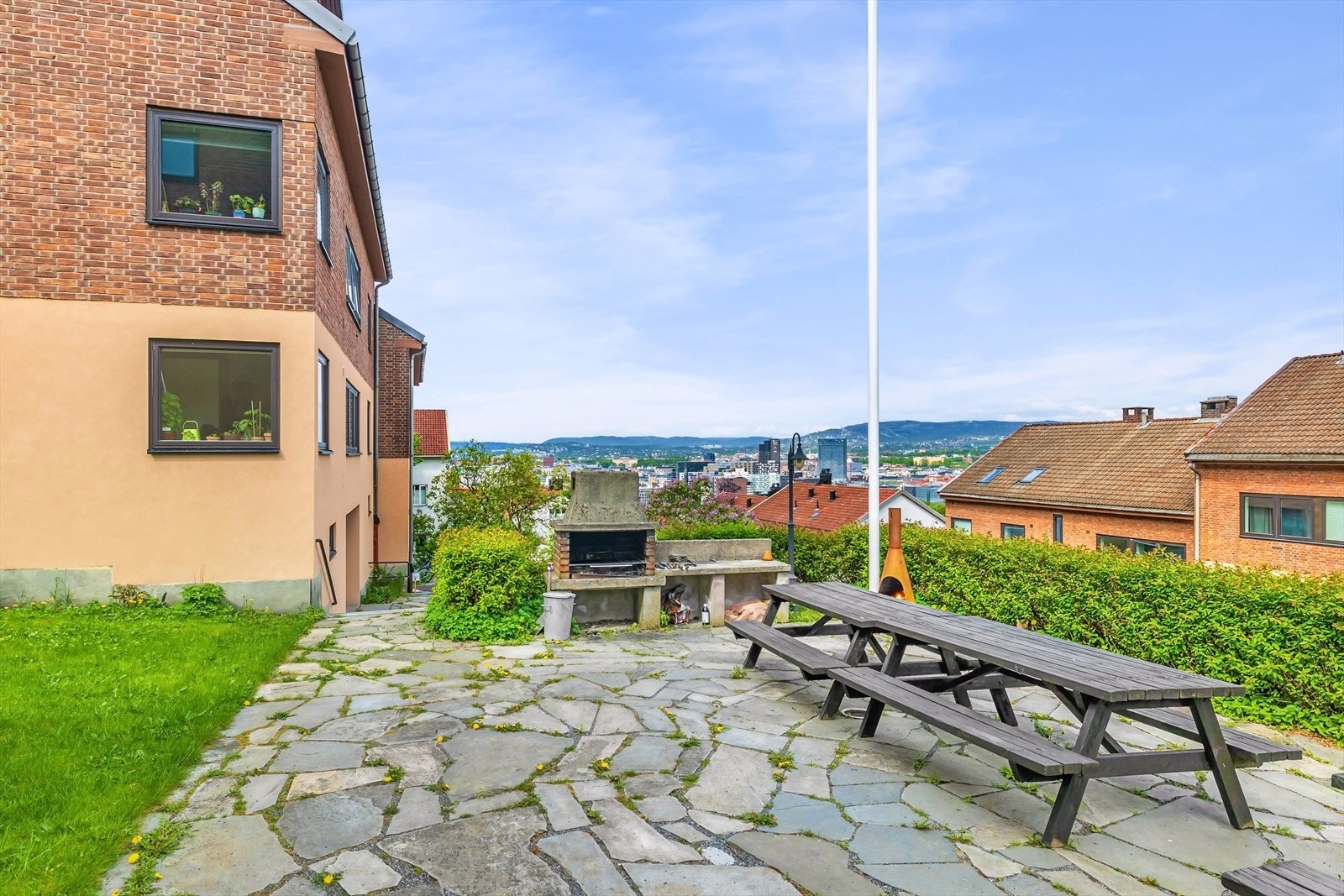 Felles uteplass med grill og sitteplasser tilgjengelig for beboere. Det er planlagt oppgradering av oppganger og grillplass Galleribilde