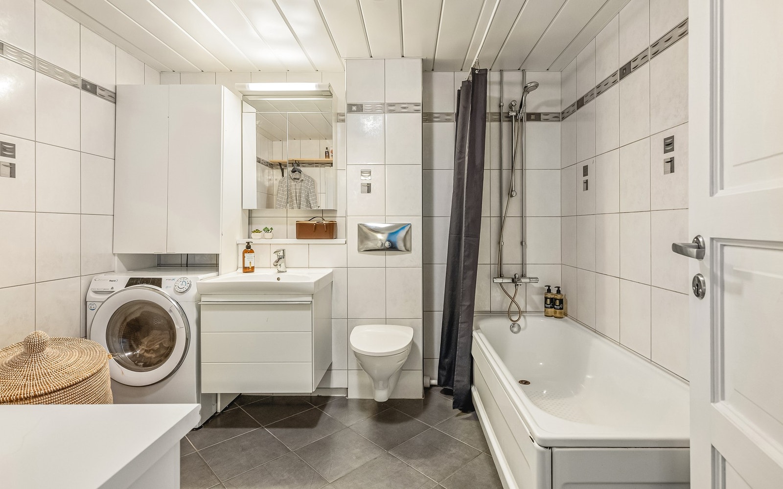 Badet inneholder innredning med, badekar, vask, toalett, og opplegg for vaskemaskin Galleribilde