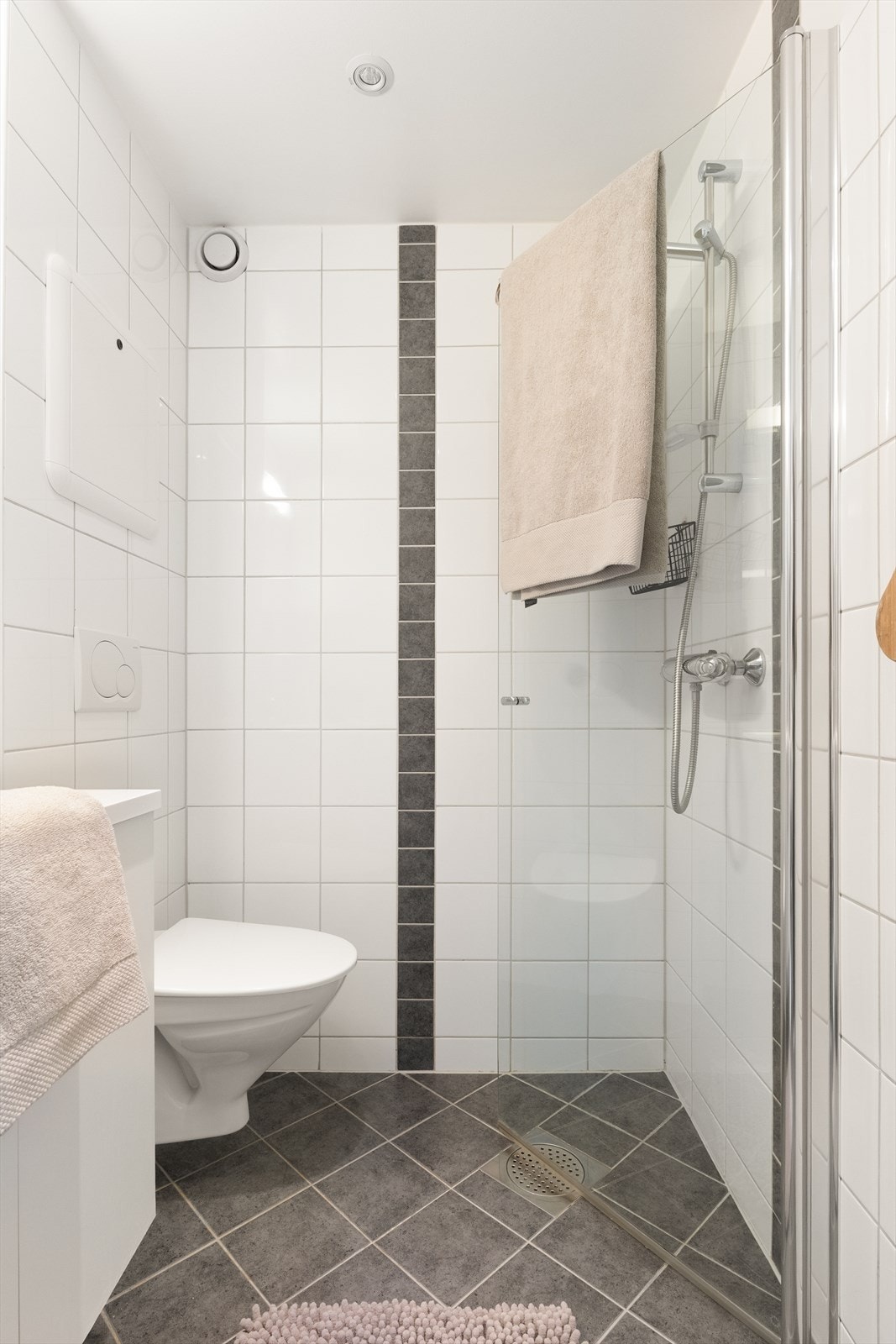 Badet er utstyrt med vegghengt servantinnredning, toalett og dusjarmatur. Her er det også montert en varmtvannsbereder på 45L fra 2021. Galleribilde