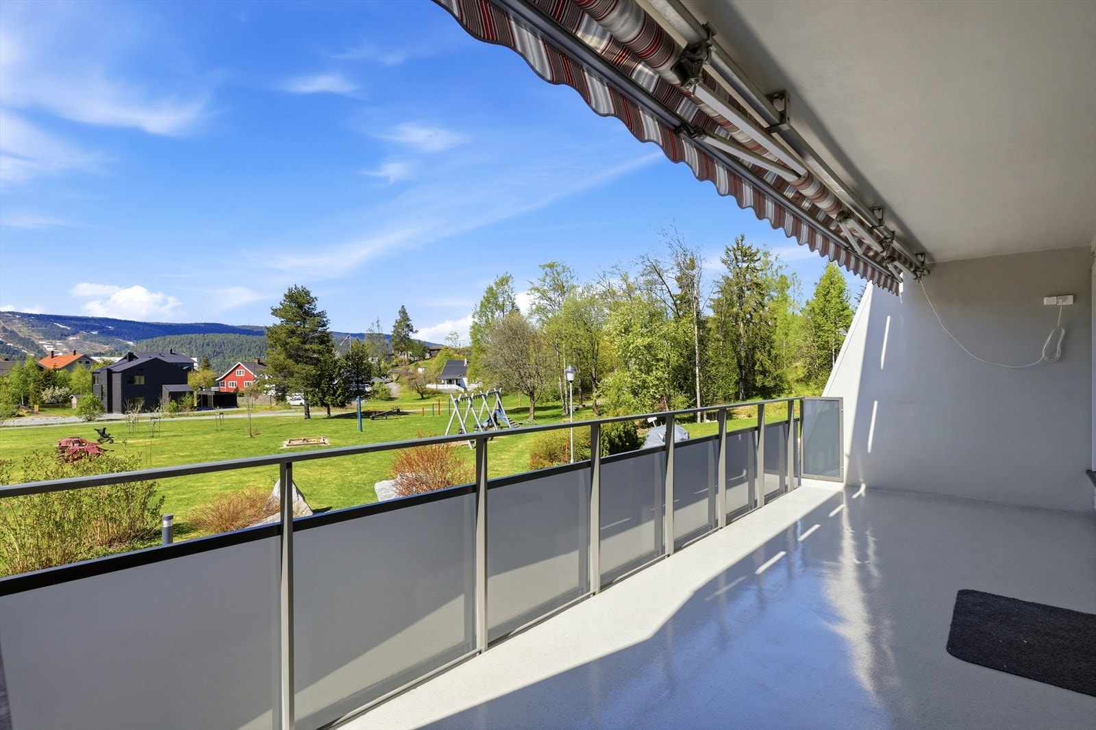 Fra balkongen er det utsikt over borettslagets grønne og velholdte fellesarealer. Galleribilde