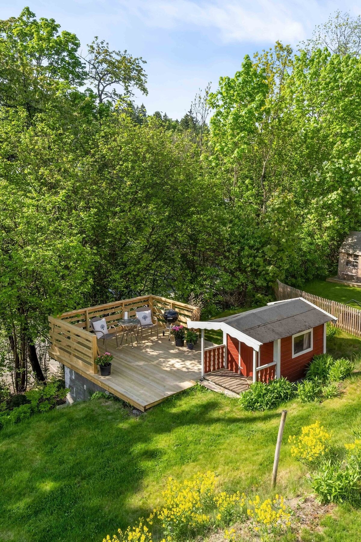 Terrassen i hagen er et herlig skjermet sted å tilbringe varme sommerdager. For de minste er det et hyggelig lekehus. Galleribilde