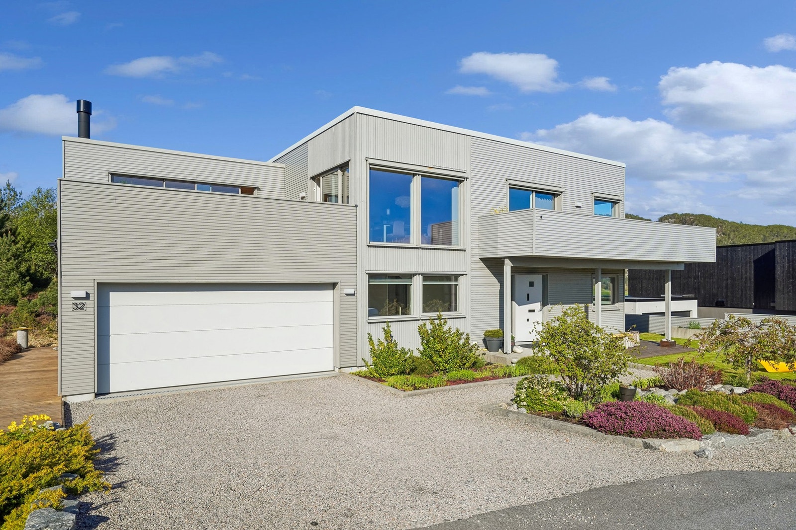 Den integrerte dobbel garasjen har god plass til to biler, og på gruset gårdsplass er det også plass til to biler. Galleribilde