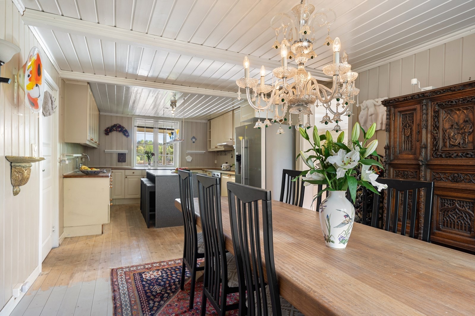 Ved siden av stuen finner vi et romslig kjøkken med åpen løsning mot spisestuen, noe som skaper en sosial og hyggelig atmosfære med god plass til et større spisebord. Galleribilde