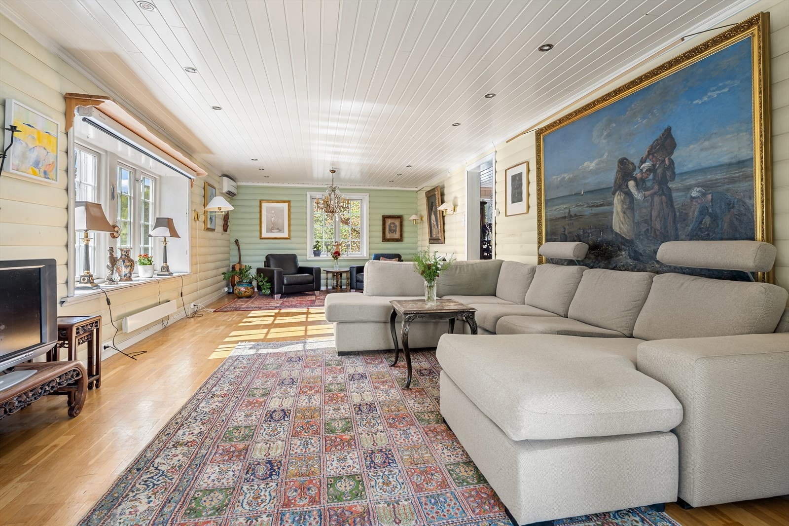 Rommet har parkett på gulv, rundpanel på vegger og malt panel i himling, noe som sammen skaper en lun og klassisk stil. Galleribilde
