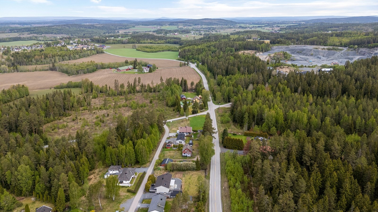 Et oversiktsbilde som viser det spredte boligfeltet omgitt av skog og jordbrukslandskap. Galleribilde