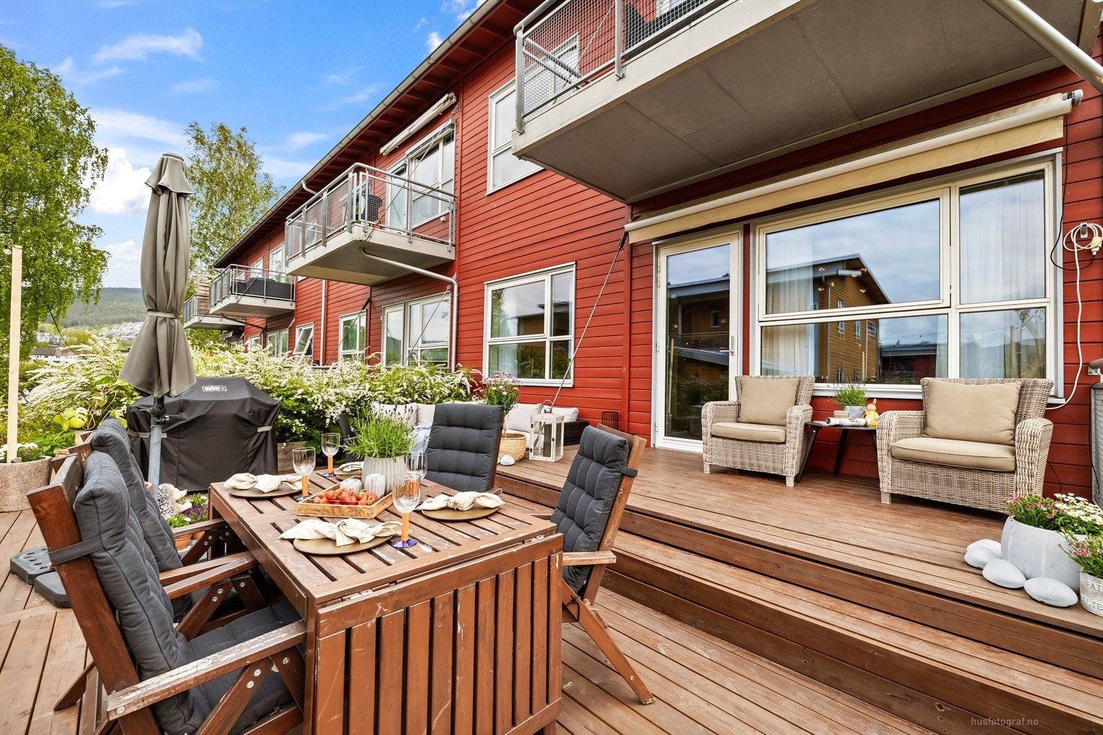 Terrassen er bygget i tre og har god plass til både spisebord og en separat loungegruppe. Galleribilde