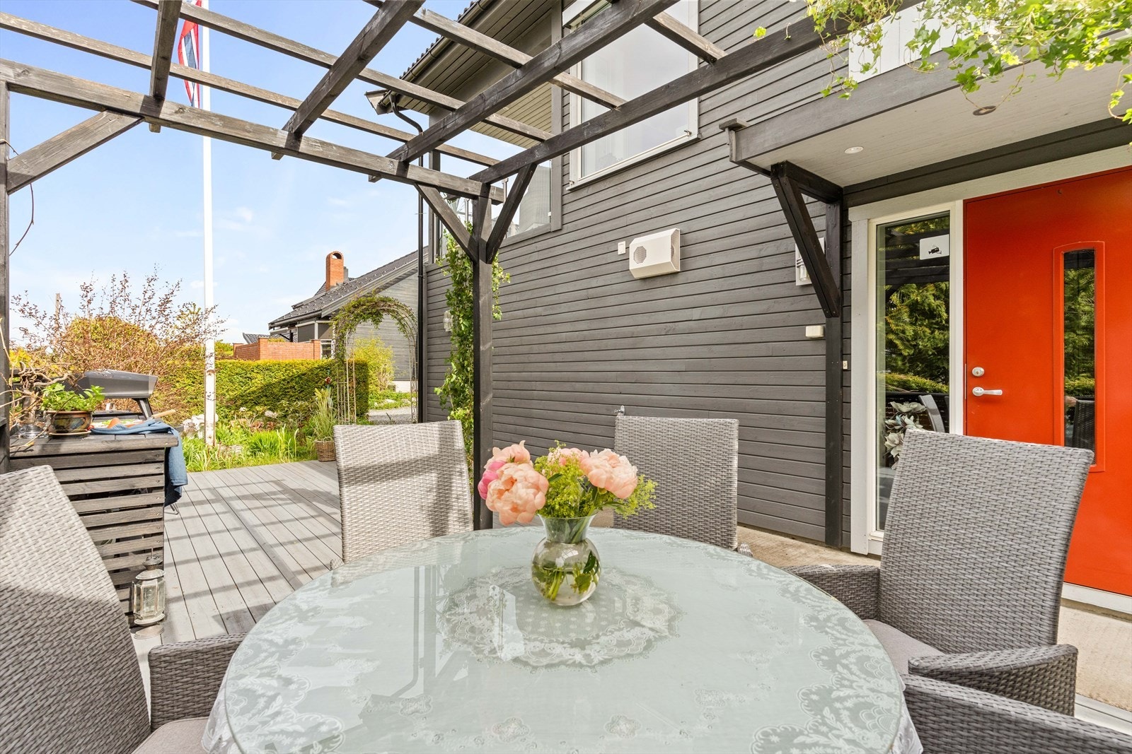 Hyggelig inngangsparti med terrasse og plass til sittegruppe. Boligens fasade fremstår pen og velholdt. Galleribilde