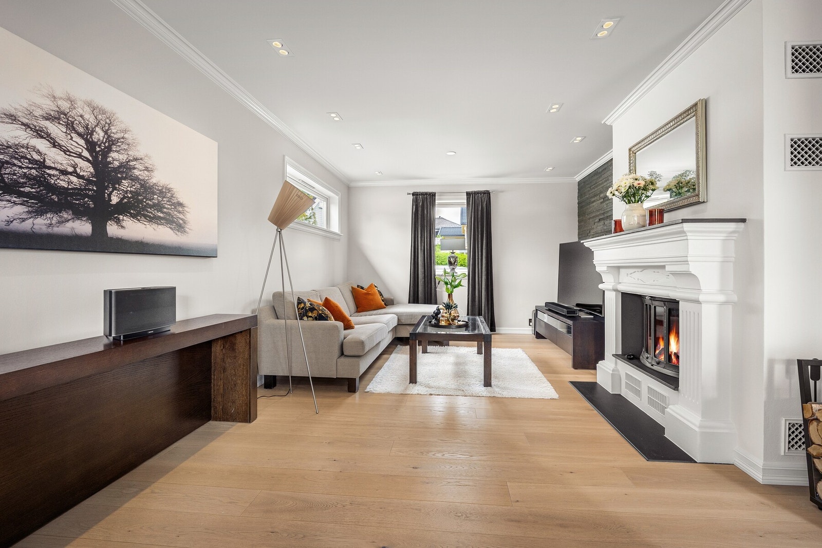 Stuen ble overflateoppusset i 2015 med blant annet ny parkett, sparklet og malt vegg/tak samt nye spotter/downlights. Den innmurte peisen med innsats blir et flott blikkfang i rommet. Galleribilde