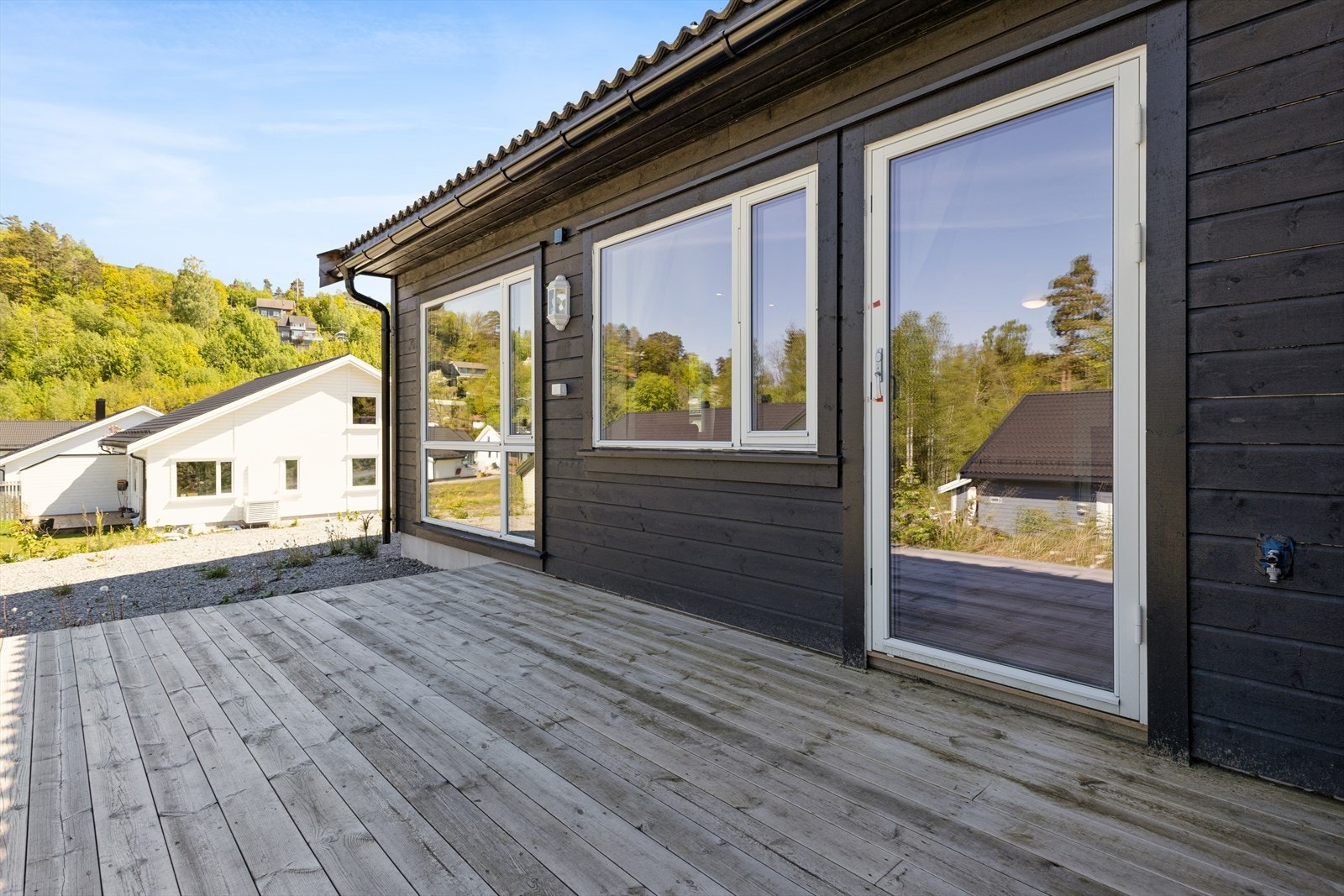 Terrassen fremstår funksjonell, men terrassegulvet har et vedlikeholdsbehov, og fundamenteringen mot terreng bør utbedres for å sikre varig stabilitet. Galleribilde