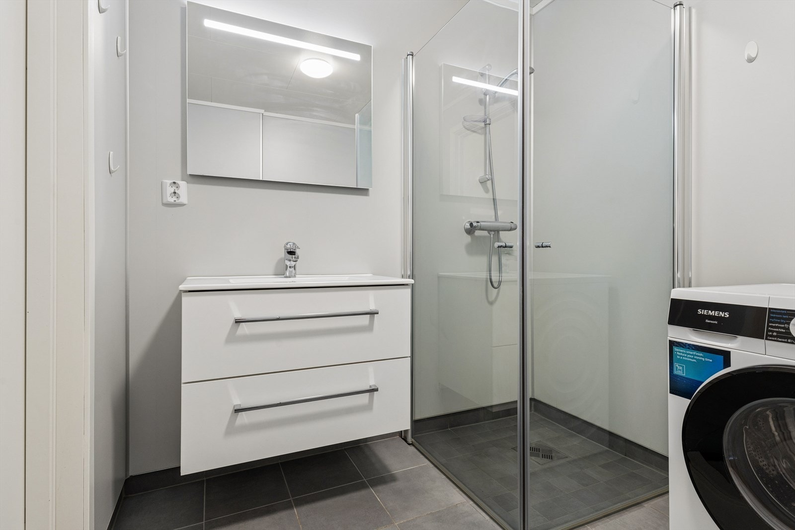 Badet er fra 2022 og har servantinnredning, dusjhjørne og våtromsplater på veggene. Galleribilde