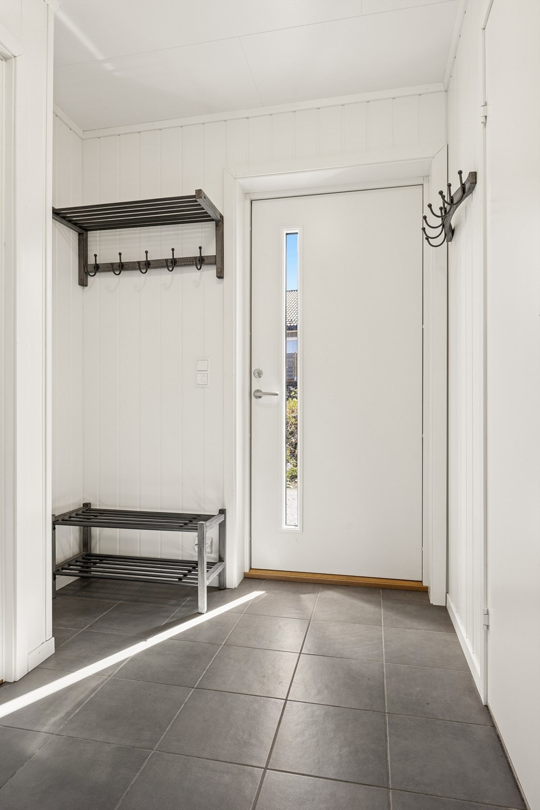 Du ønskes velkommen inn i en entré med flislagt gulv og god plass til oppheng av yttertøy. Galleribilde