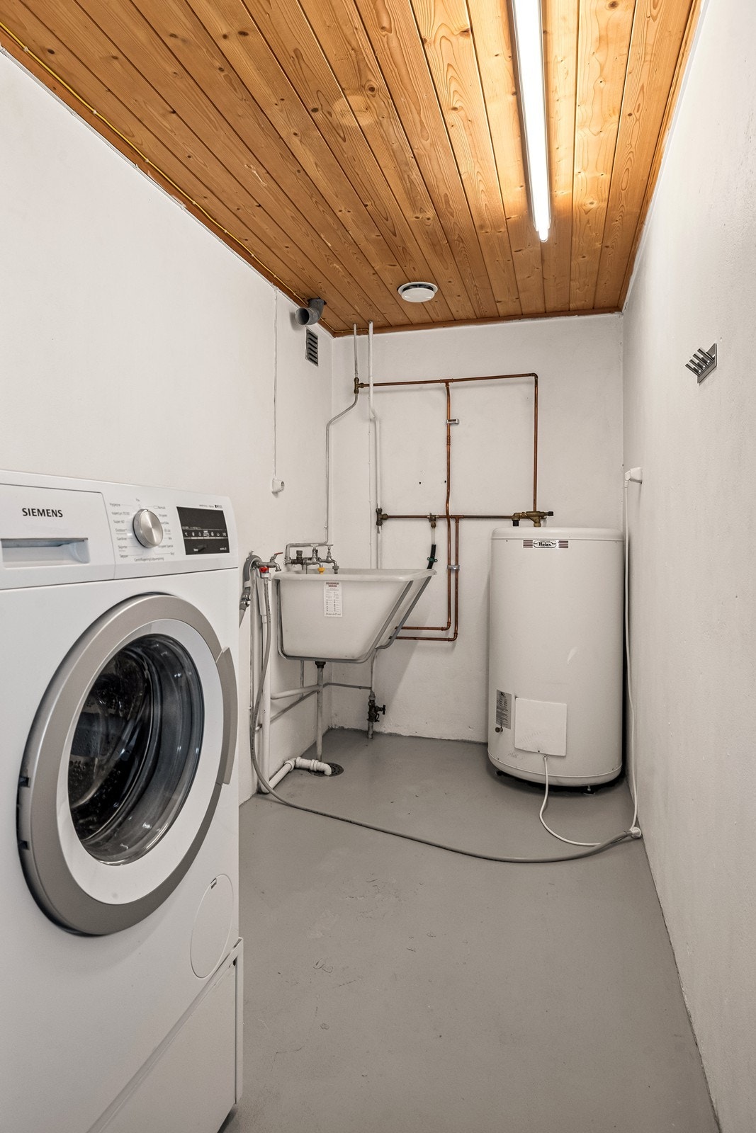 Separat vaskerom med opplegg for vaskemaskin, utslagskum og en 200-liters varmtvannstank. Galleribilde