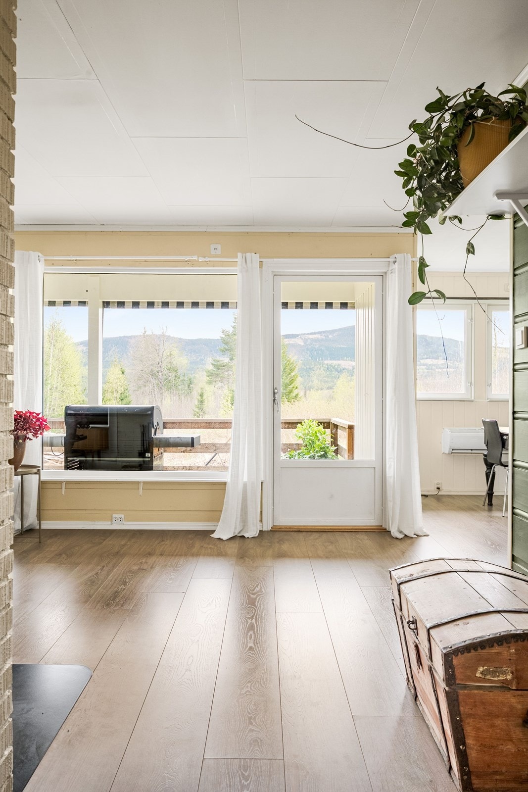 Stuen har flere store vinduer som slipper inn rikelig med naturlig lys. Galleribilde