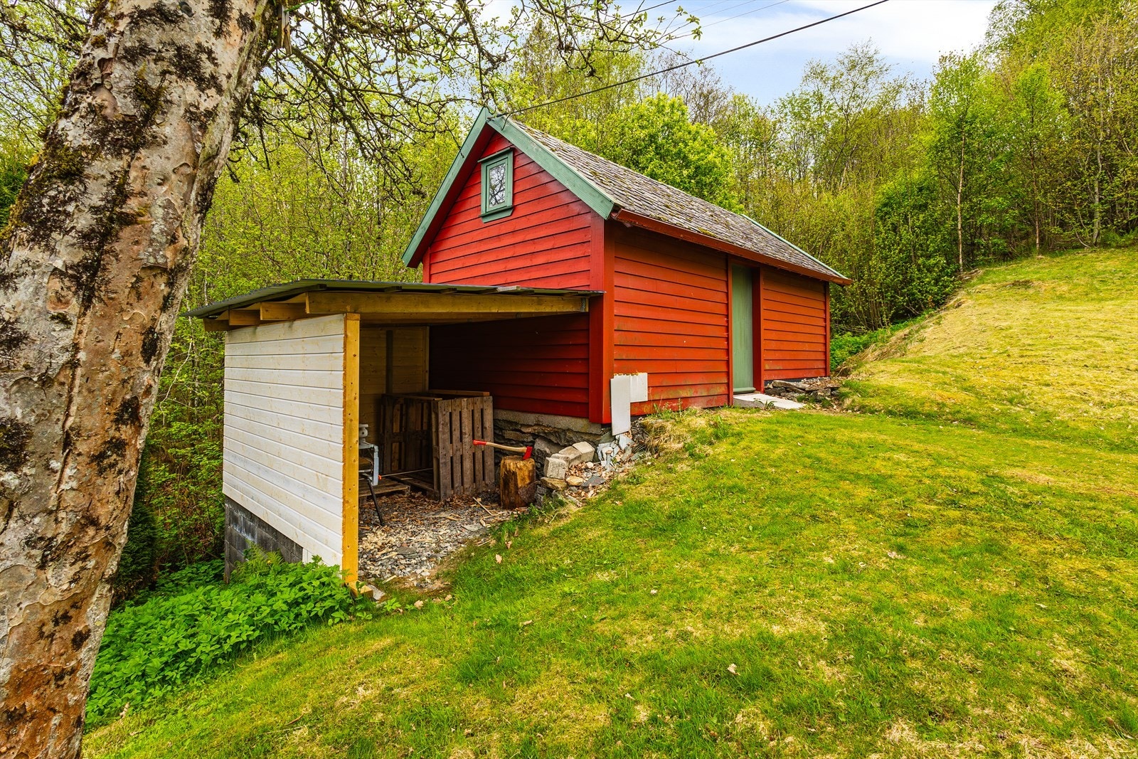 I hagen finnes et fint uthus og vedskjul. Galleribilde