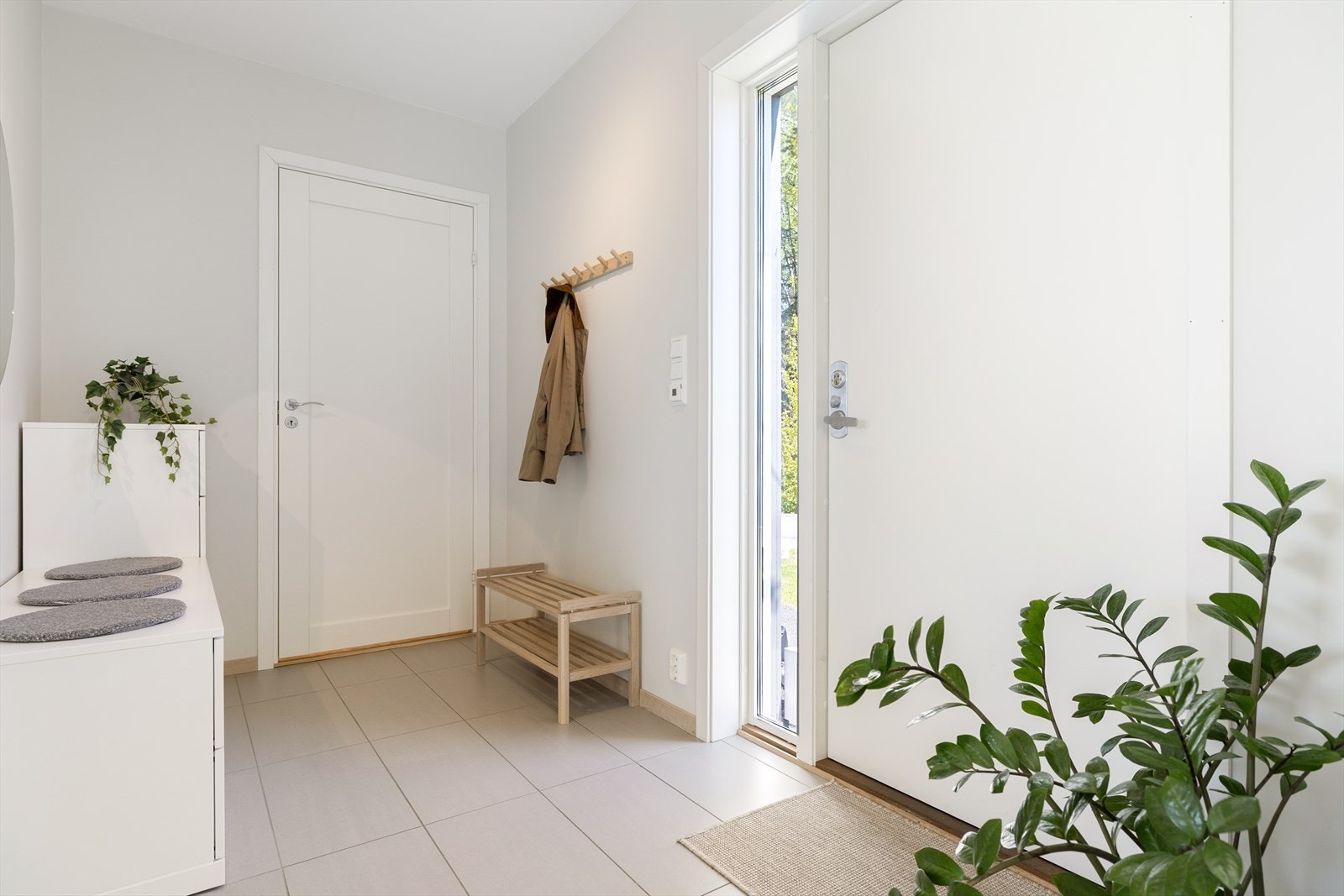 Entréen gir et fint førsteinntrykk, noe som er gjennomgående for øvrige rom i boligen. I entréen har man plass til oppbevaring av yttertøy og sko, rikelig med plass til kommode eller garderobeskap. Pent flislagt gulv med varmekabler og belysning. Galleribilde