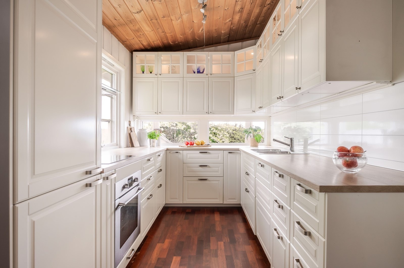 Kjøkkenet har godt med skap- og benkeplass med hvite profilerte fronter. Laminert benkeplate med nedfelt dobbel oppvaskkum. Galleribilde