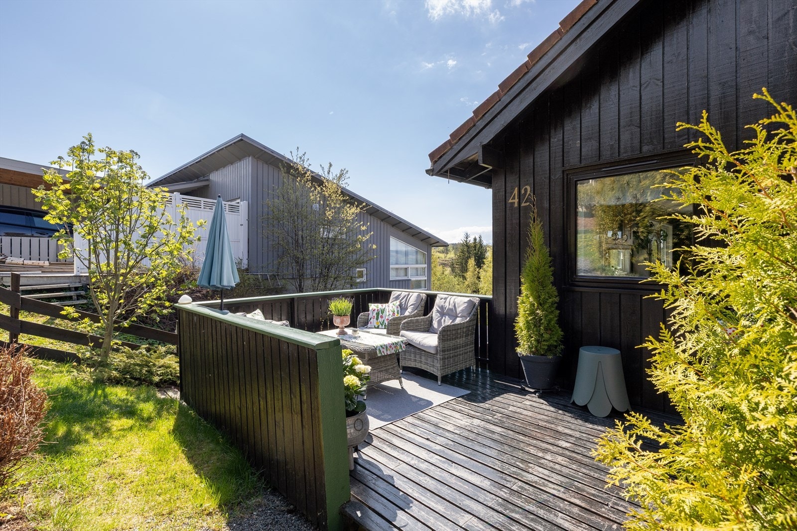 Tomten er pent opparbeidet med plen og flere treterrasser som skaper hyggelige soner i hagen. Galleribilde