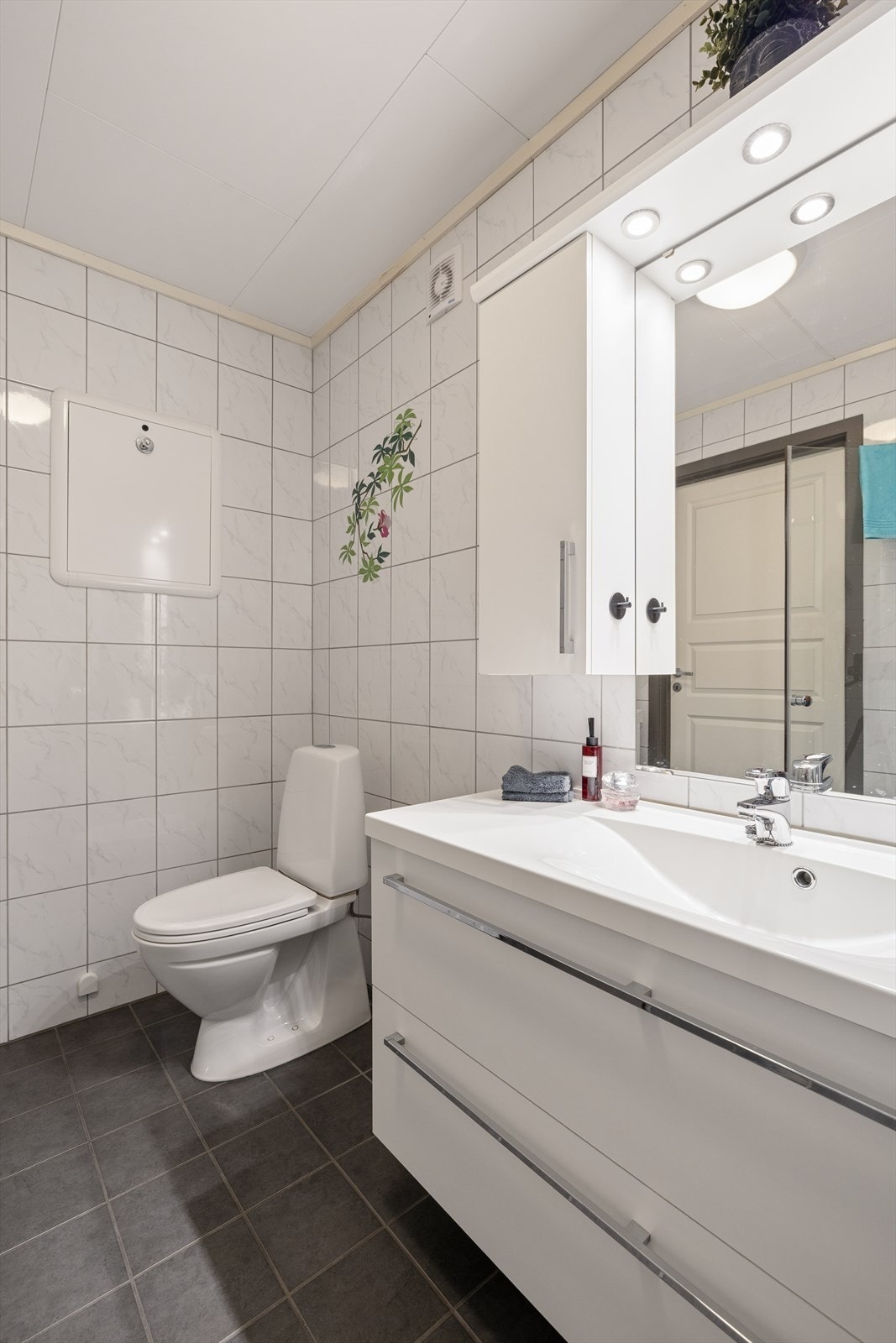 Badet er funksjonelt innredet med dusjhjørne, toalett, servantinnredning og opplegg for vaskemaskin. Galleribilde