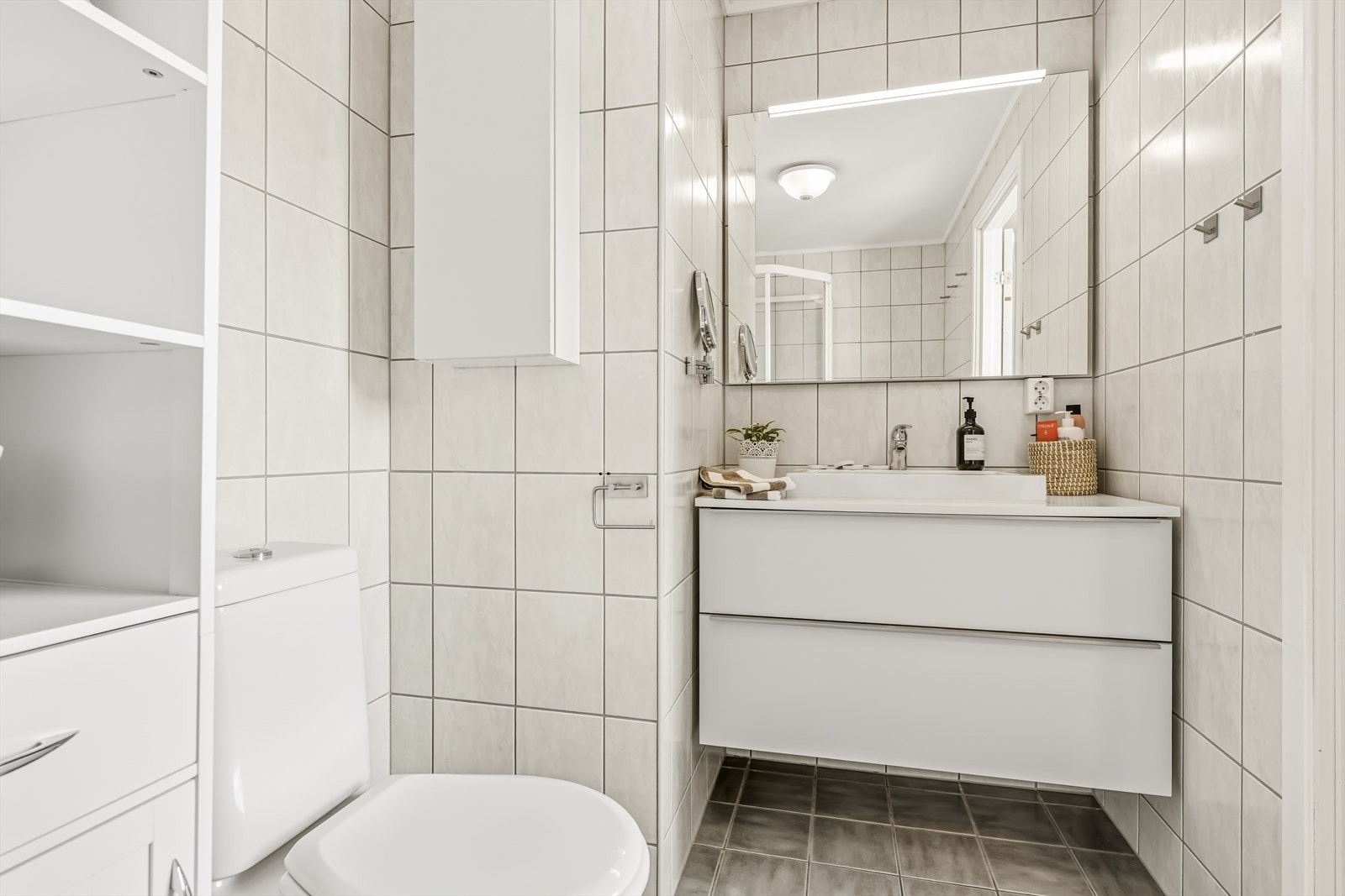 Baderomsinnredning med nedfelt servant og god oppbevaringsplass. Galleribilde