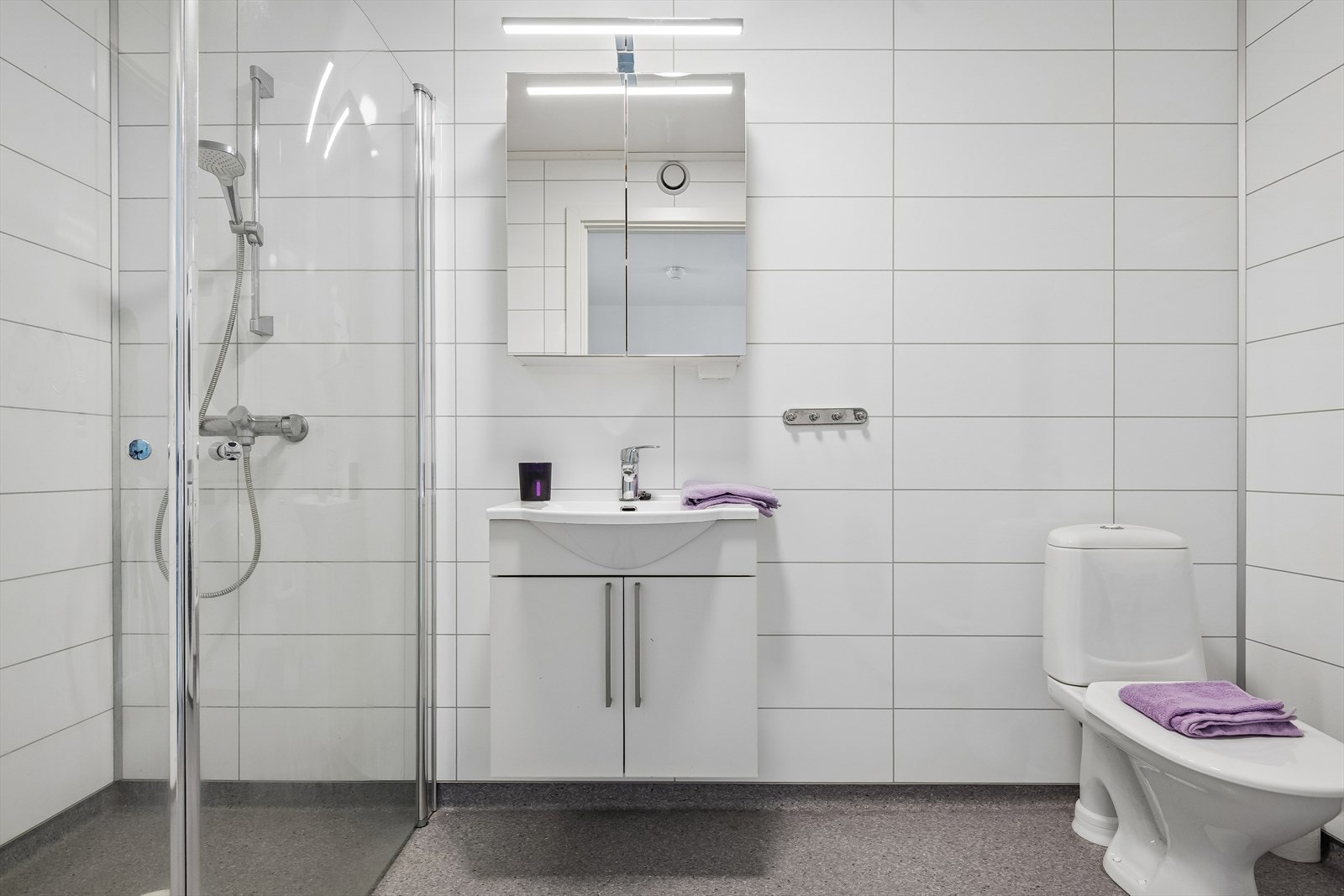 Badet i andre etasje har baderomsplater på veggene og vinylbelegg med varmekabler på gulvet. Galleribilde