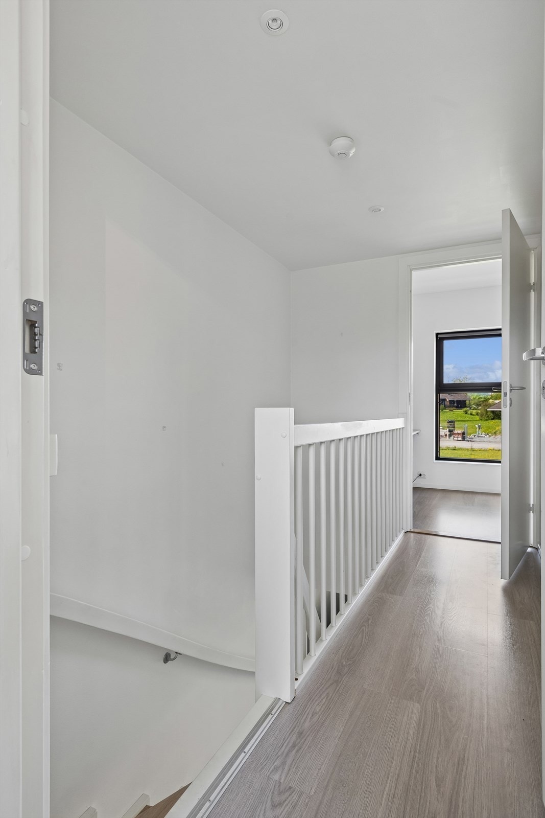 Malt trapp med folierte trinn leder opp til andre etasje, som inneholder to soverom og bad. Galleribilde