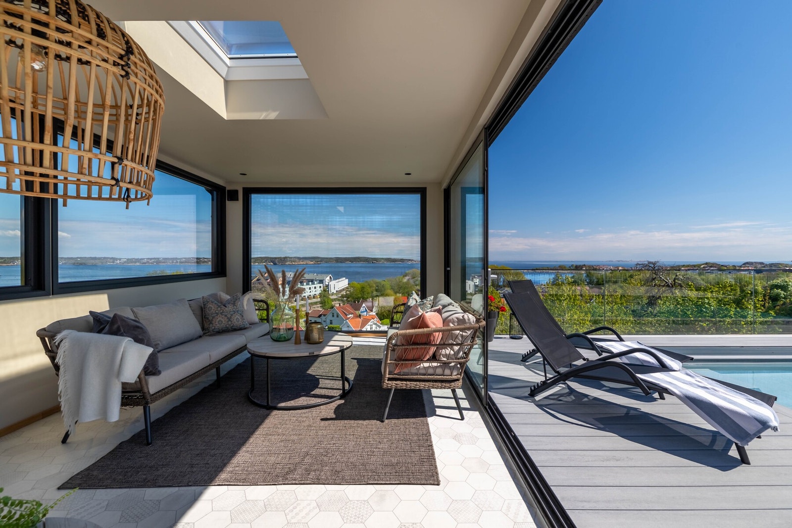 Lys og moderne utestue med store vindusflater og flott utsikt. Direkte utgang til solrik terrasse med basseng gir en eksklusiv atmosfære. Galleribilde