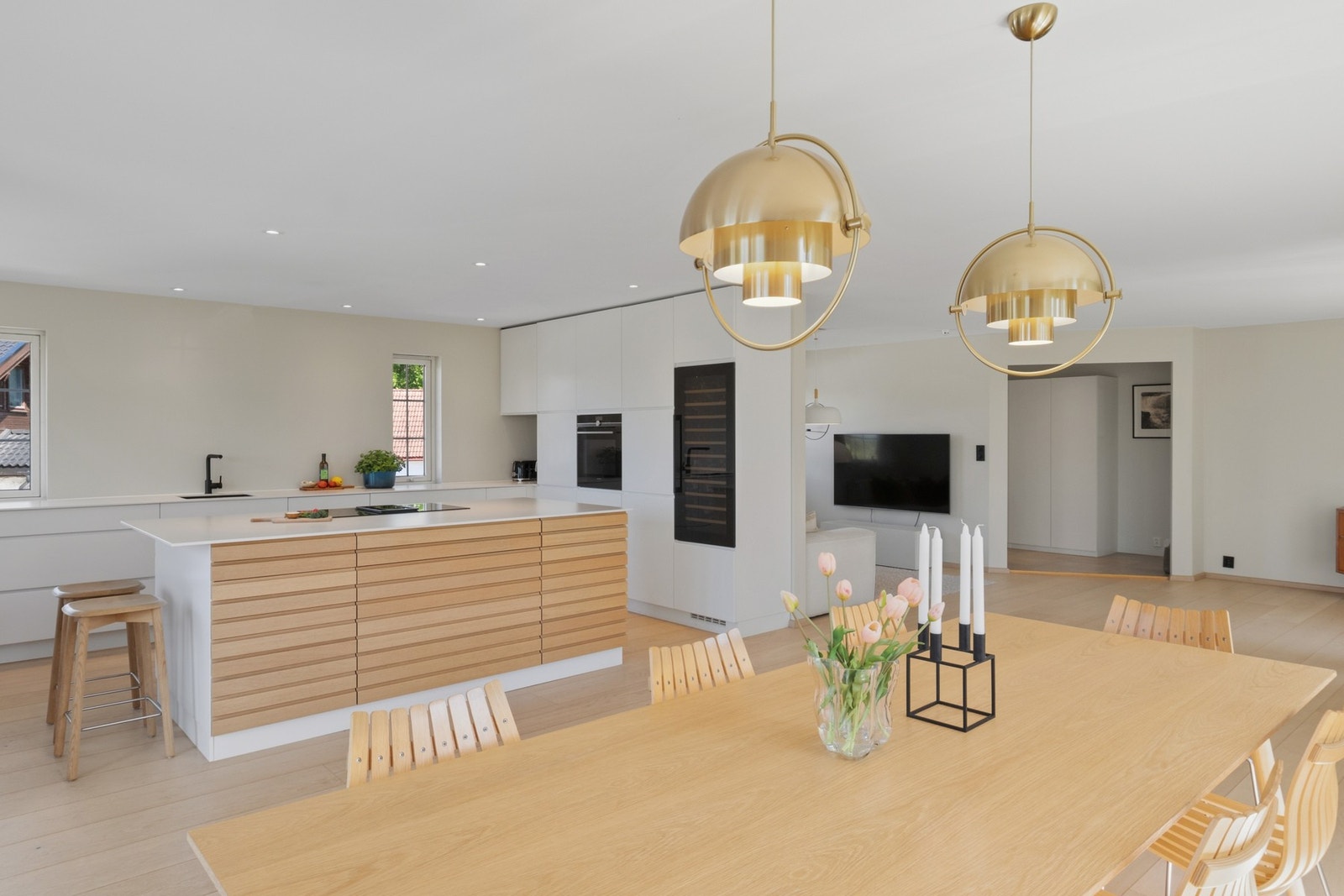 Innredningen er fra 2019, med hvite, glatte fronter, matchende benkeplate av laminat og nedfelt oppvaskkum i sort design. Galleribilde